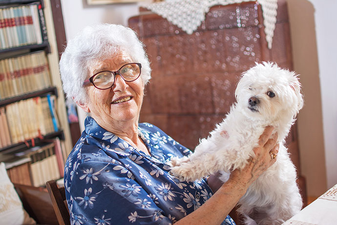 older woman holding a white dog